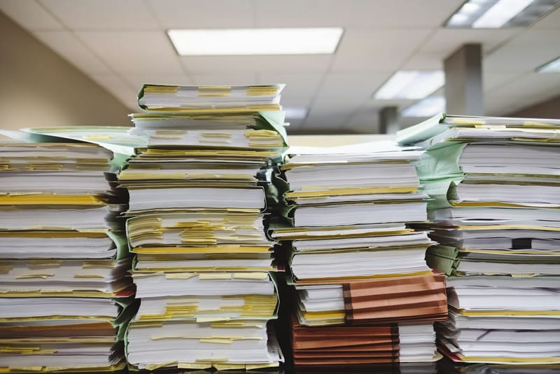 Stacks of bound case documents flagged with index tabs in an office