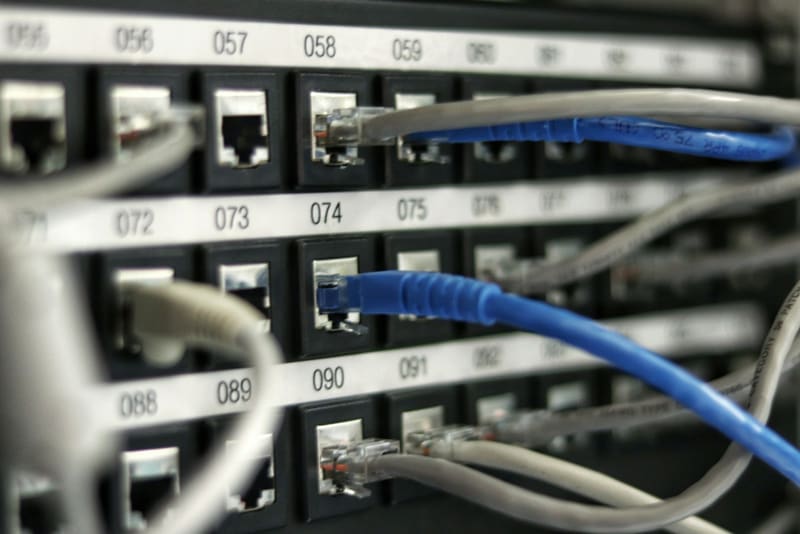 A numbered network patch panel with ethernet cables connected