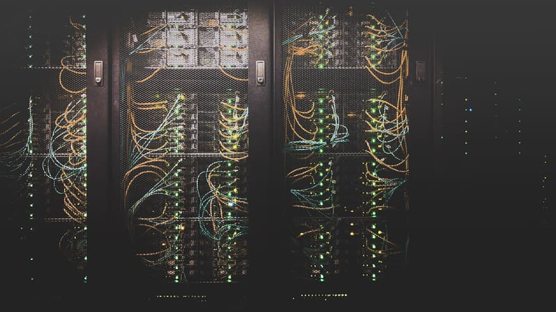 Server racks threaded with colored fiber patch cables
